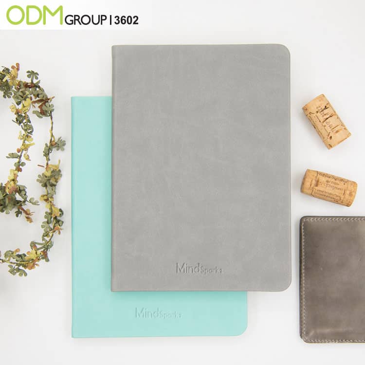 Branded leather notebooks in grey and mint green with MindSparkz logo.