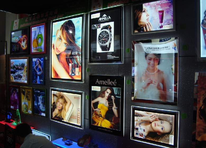 A display of various lightbox posters with vibrant images and promotional content.