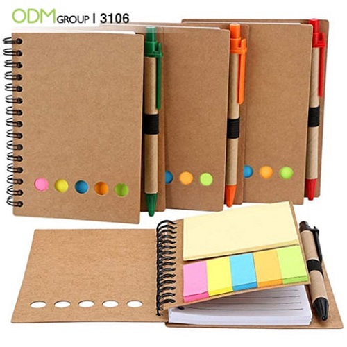 Eco-friendly notebooks with colorful sticky notes and pens.
