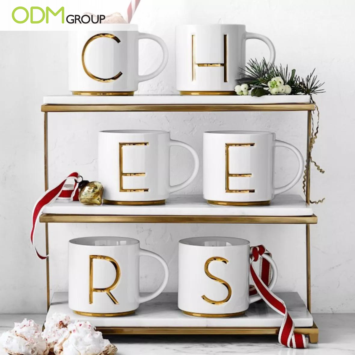 White ceramic mugs with gold monogram letters.