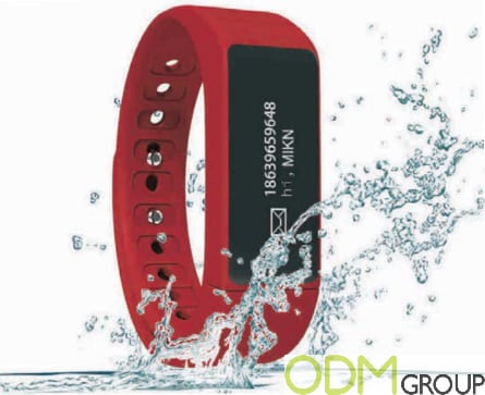 Red waterproof fitness tracker with water splashes.