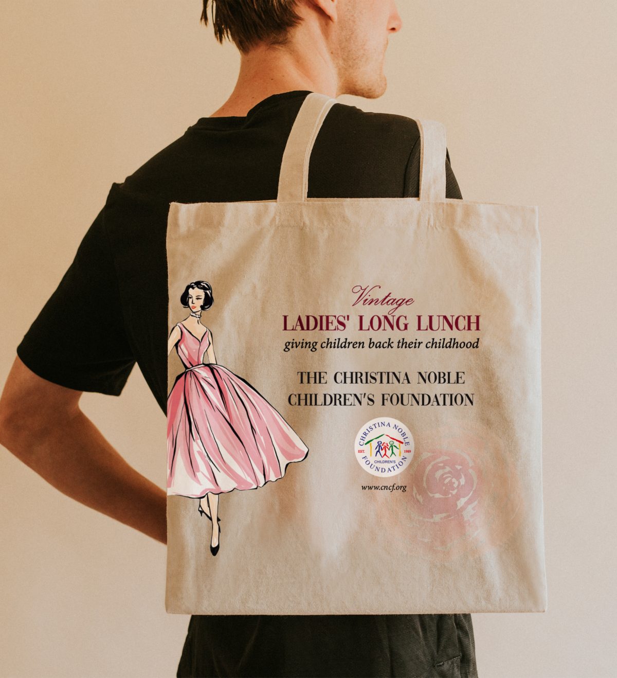 Person holding a canvas tote bag with a vintage ladies' lunch design.